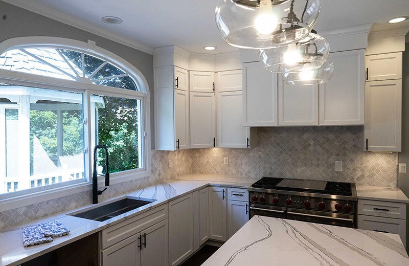 Whole house remodel - kitchen with white cabinets and marble island