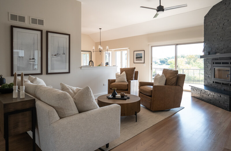 Looking from the living room to the fireplace and kitchen eating area